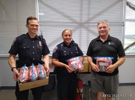 Jack Williams with Changing Footprints and  IMPD NW District Officers receiving  donated (from HDC) emergency food packs for their squad cards to help those in need